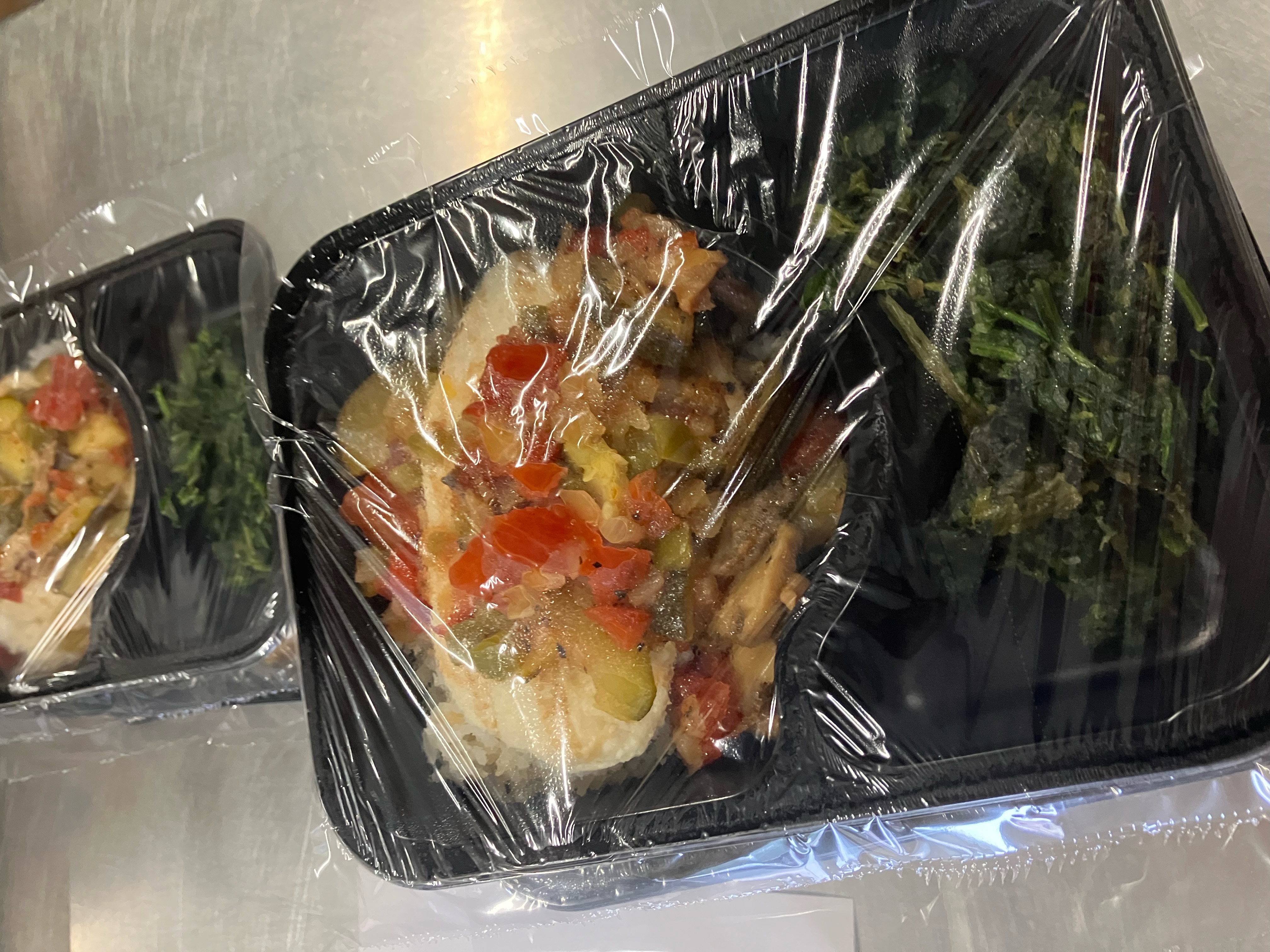 Chicken with sauteed vegetables, jasmine coconut rice, spinach, wheat bread, and fresh fruit.