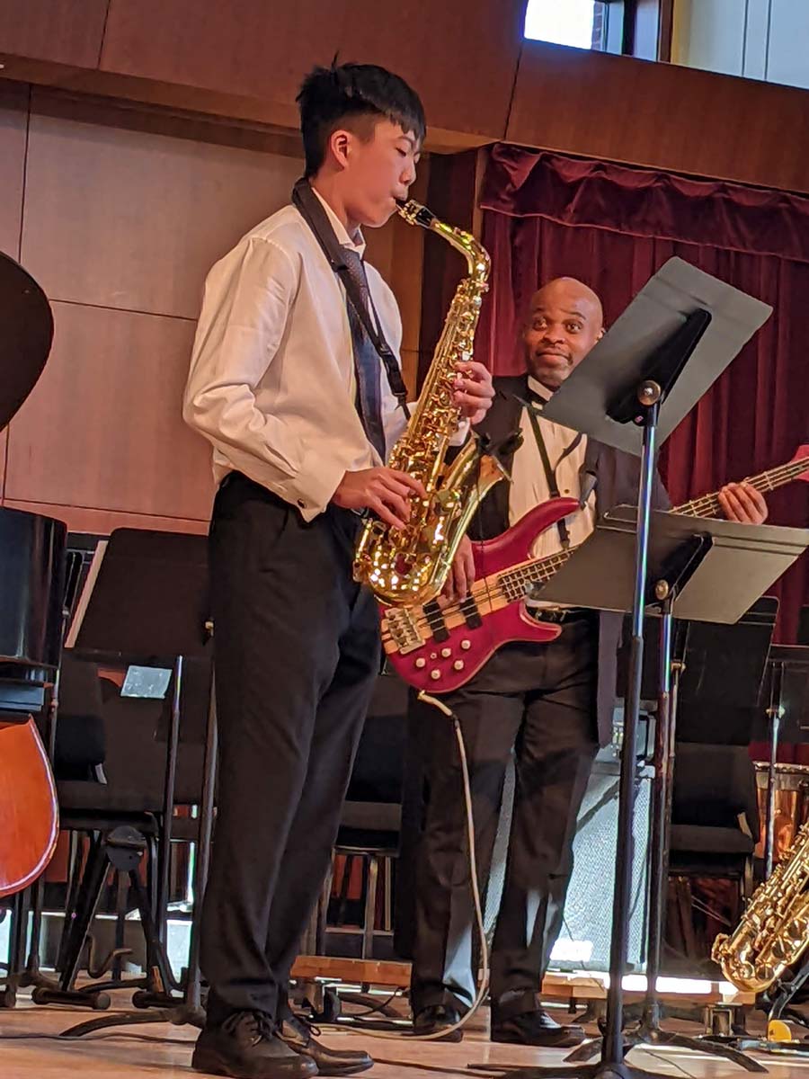 Musicians play saxophone and bass at the 2022 NMH benefit concert