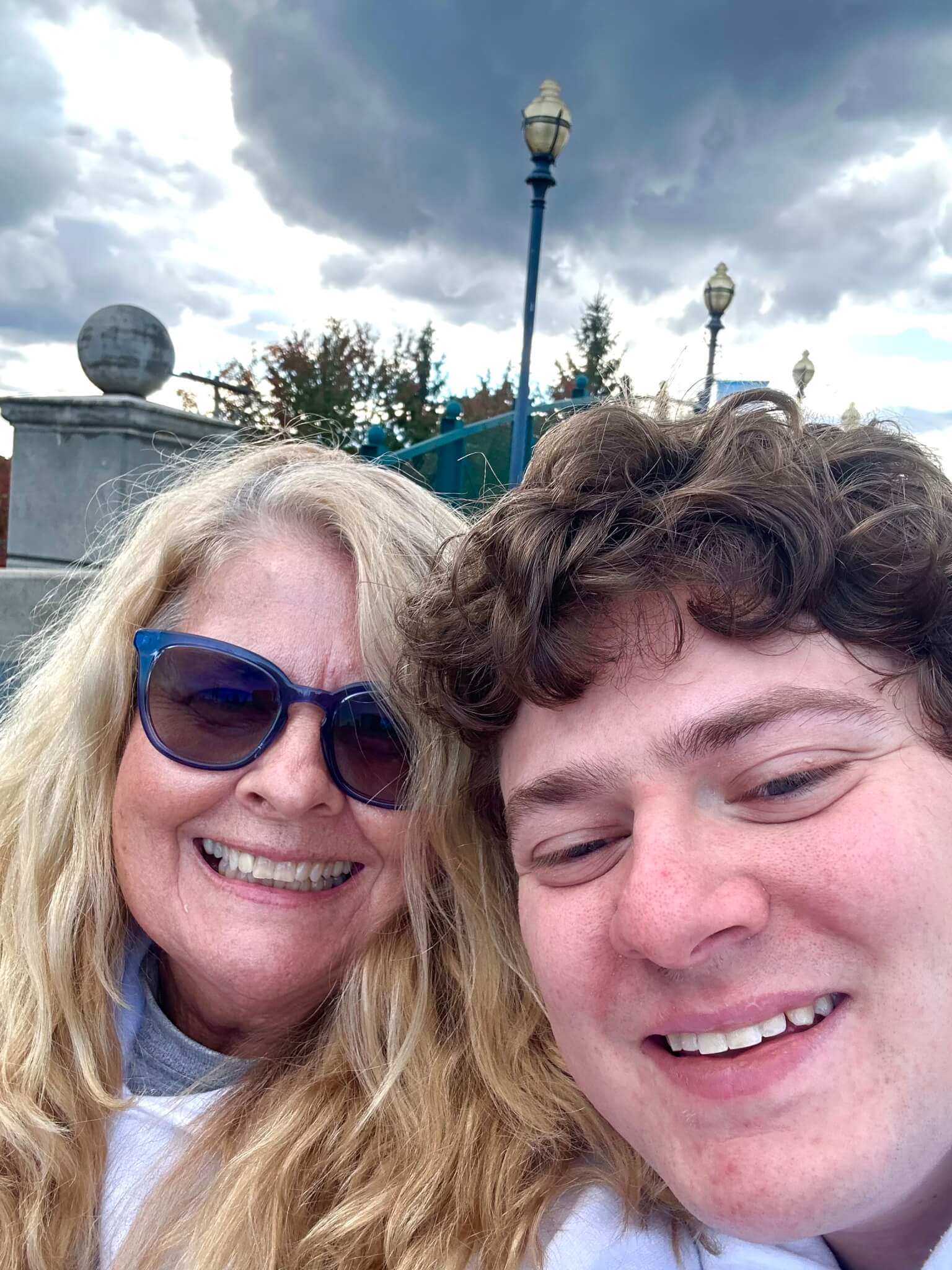 Andrea and Max selfie outside with clouds as backdrop