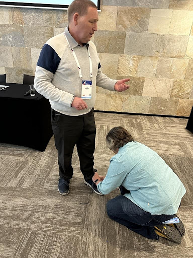 Kate Clayton-Jones at the International Symposium for the Diabetic Foot held in the Hague in May 2023, demonstrating to an individual with Type 1 diabetes the huge positive impact of securing the heel.