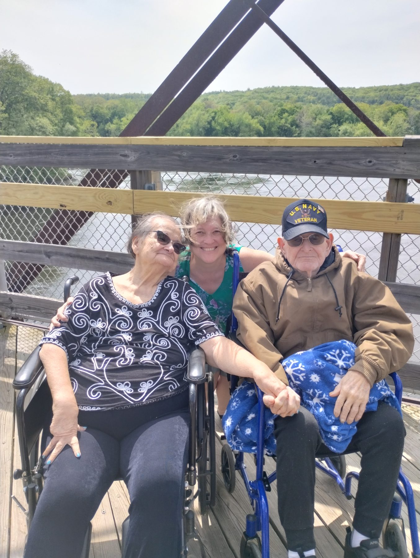 Robin Chabot with her parents, Barbara Welcome and Lawrence G. Welcome, Jr., in fromt of a bridge.