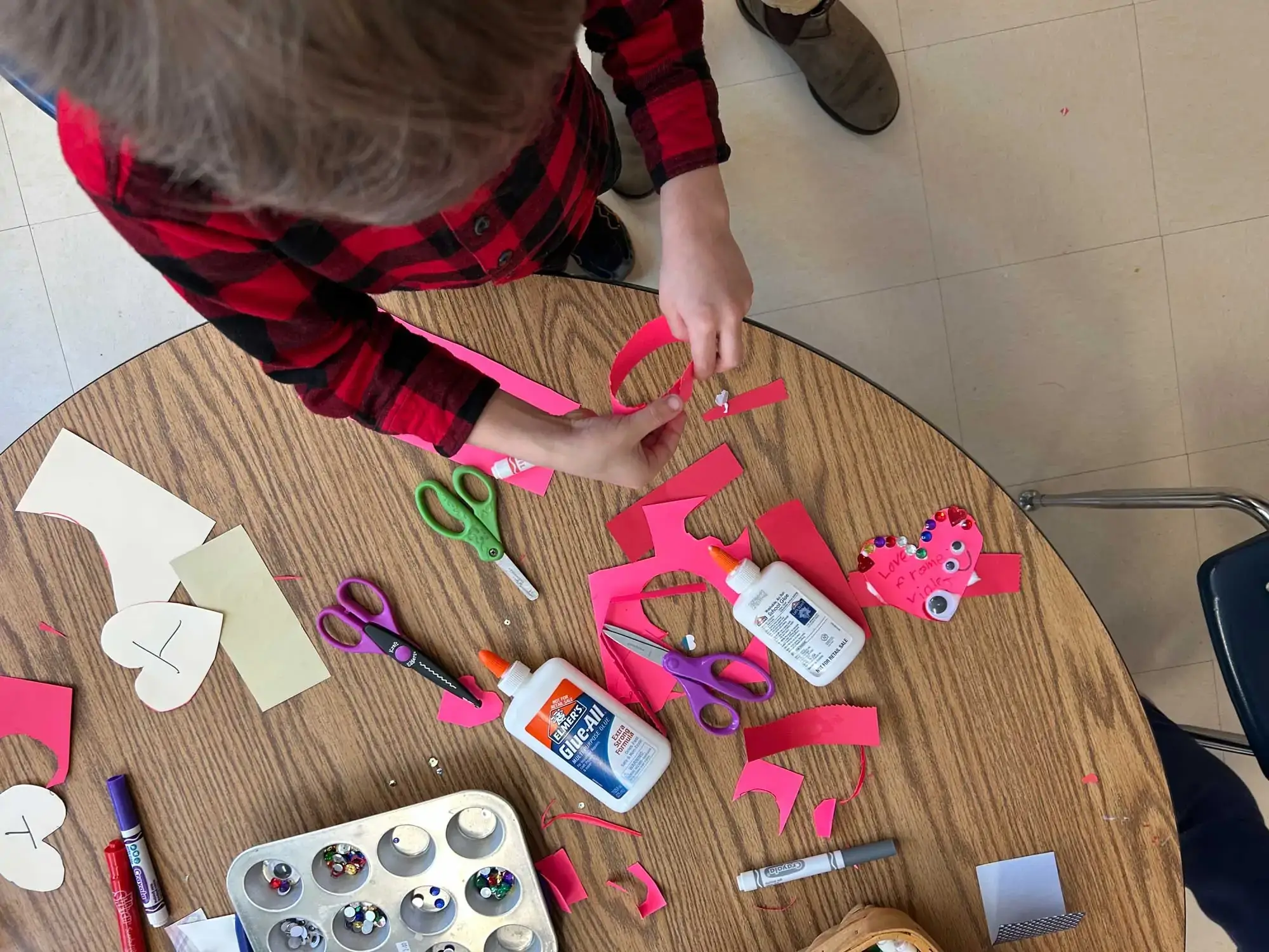 A child working on valentine cards