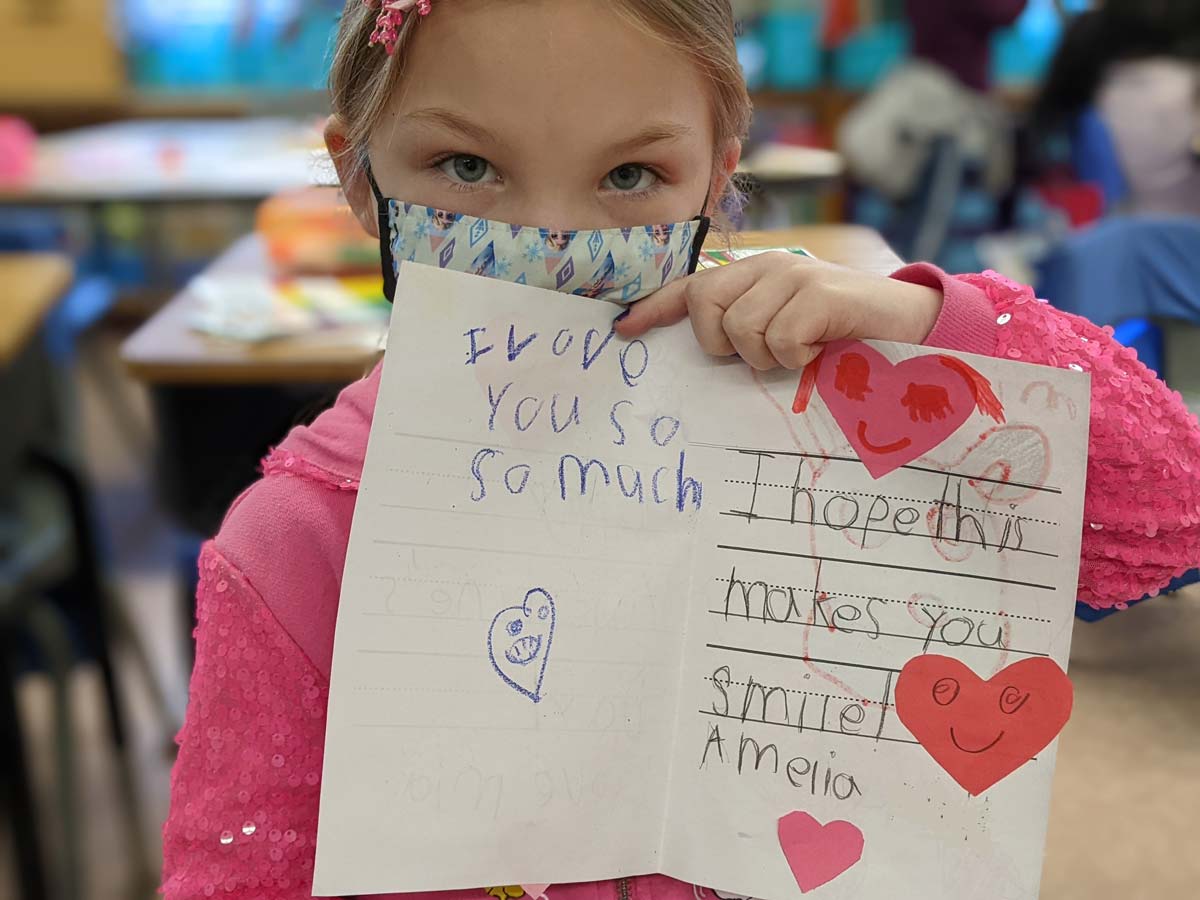 A student holds up a handmade valentine