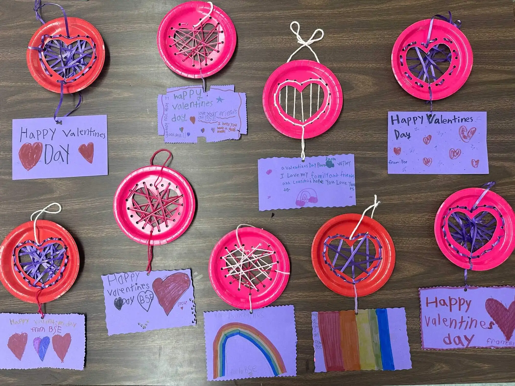 Valentines made of bright paper plates with heart cutouts woven with yarn