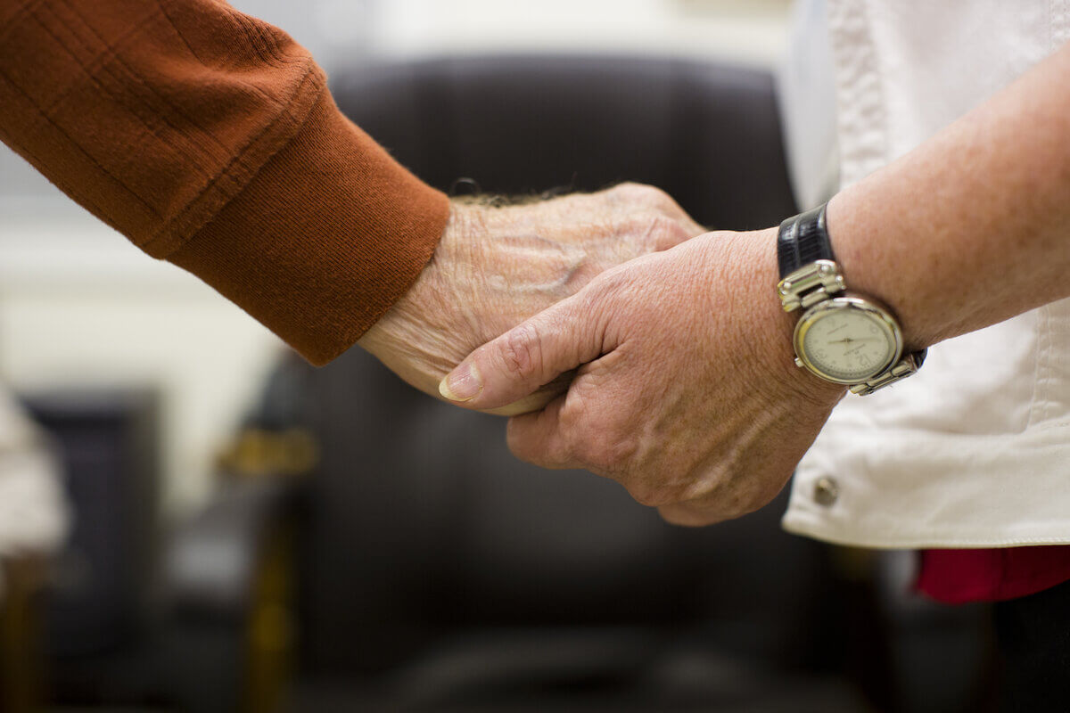 Elderly hand holding a younger hand