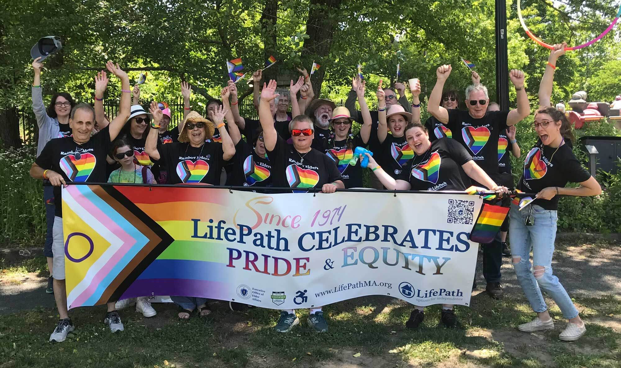 Supporters gather behind a banner that says "LifePath Celebrates Pride and Equity"