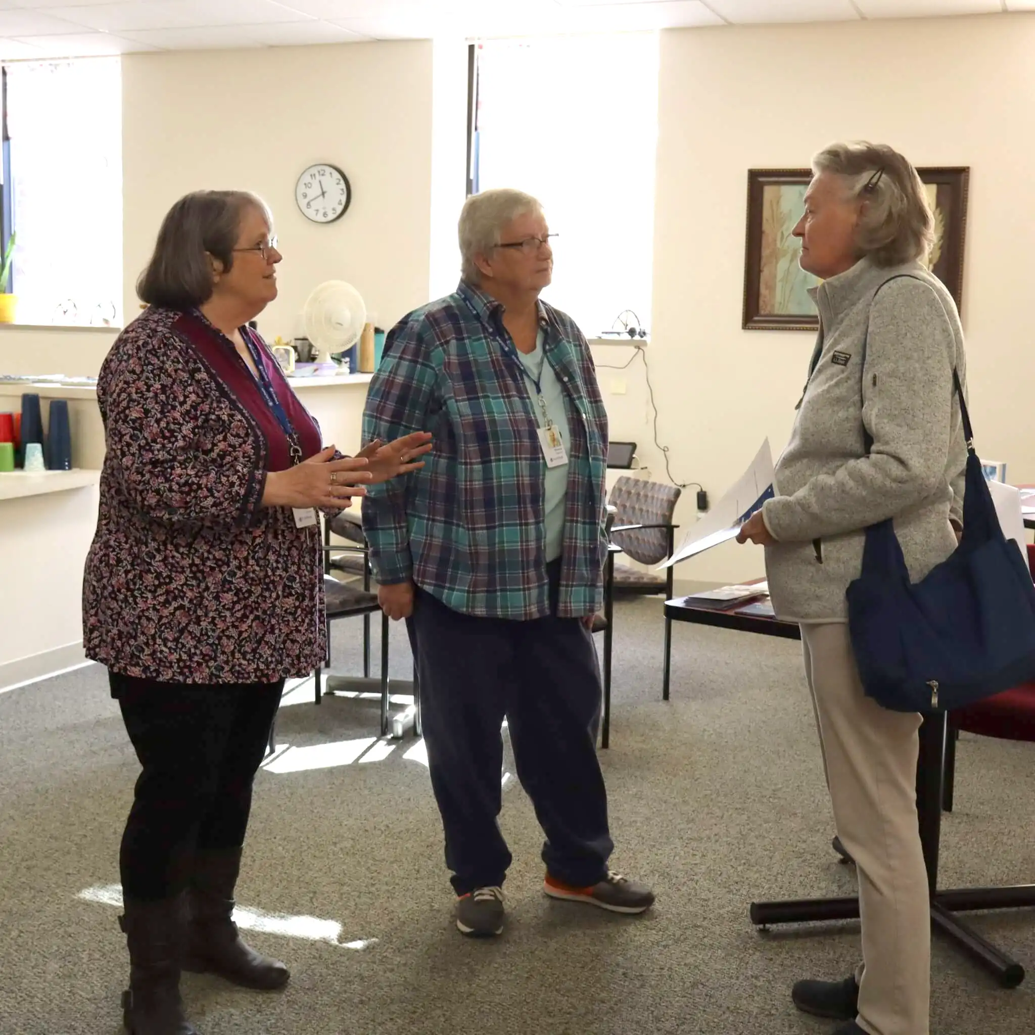 Three women standing and conversing in a building