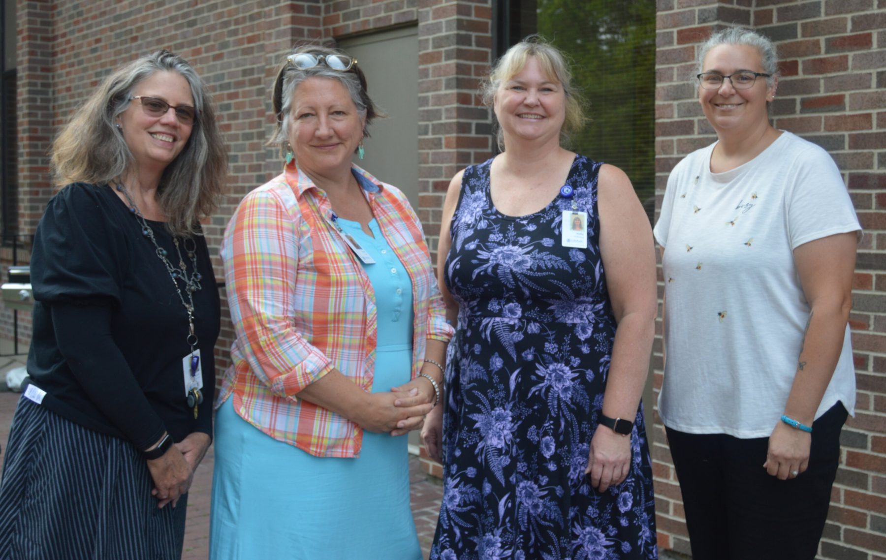 (Left to right) Diane Robie, Carol Foote, Holly Holloway, and Danielle Boyd standing outside in front of our brick office.