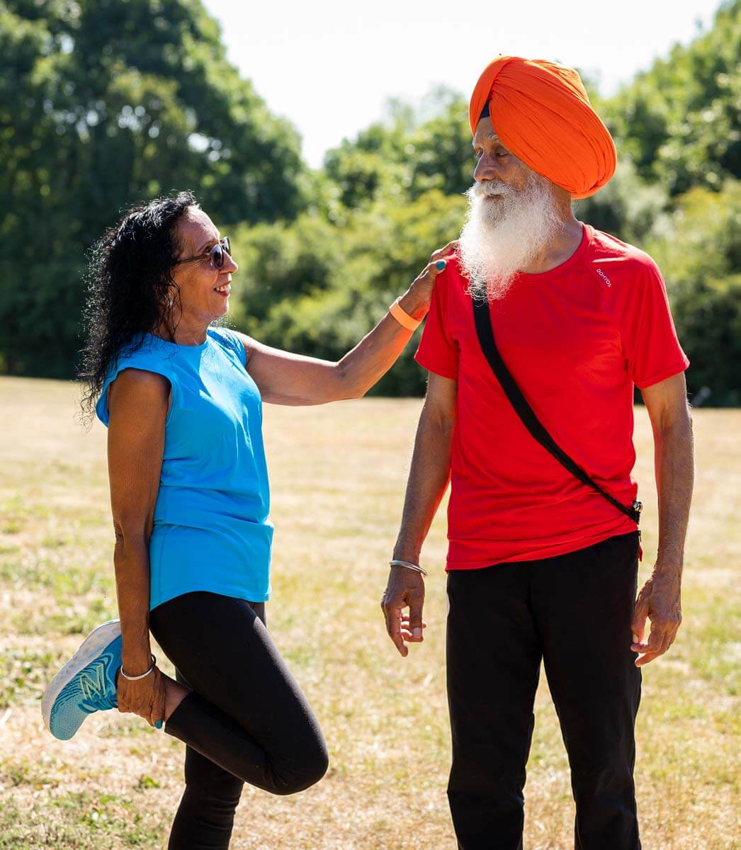 Two older adults stretching outdoors