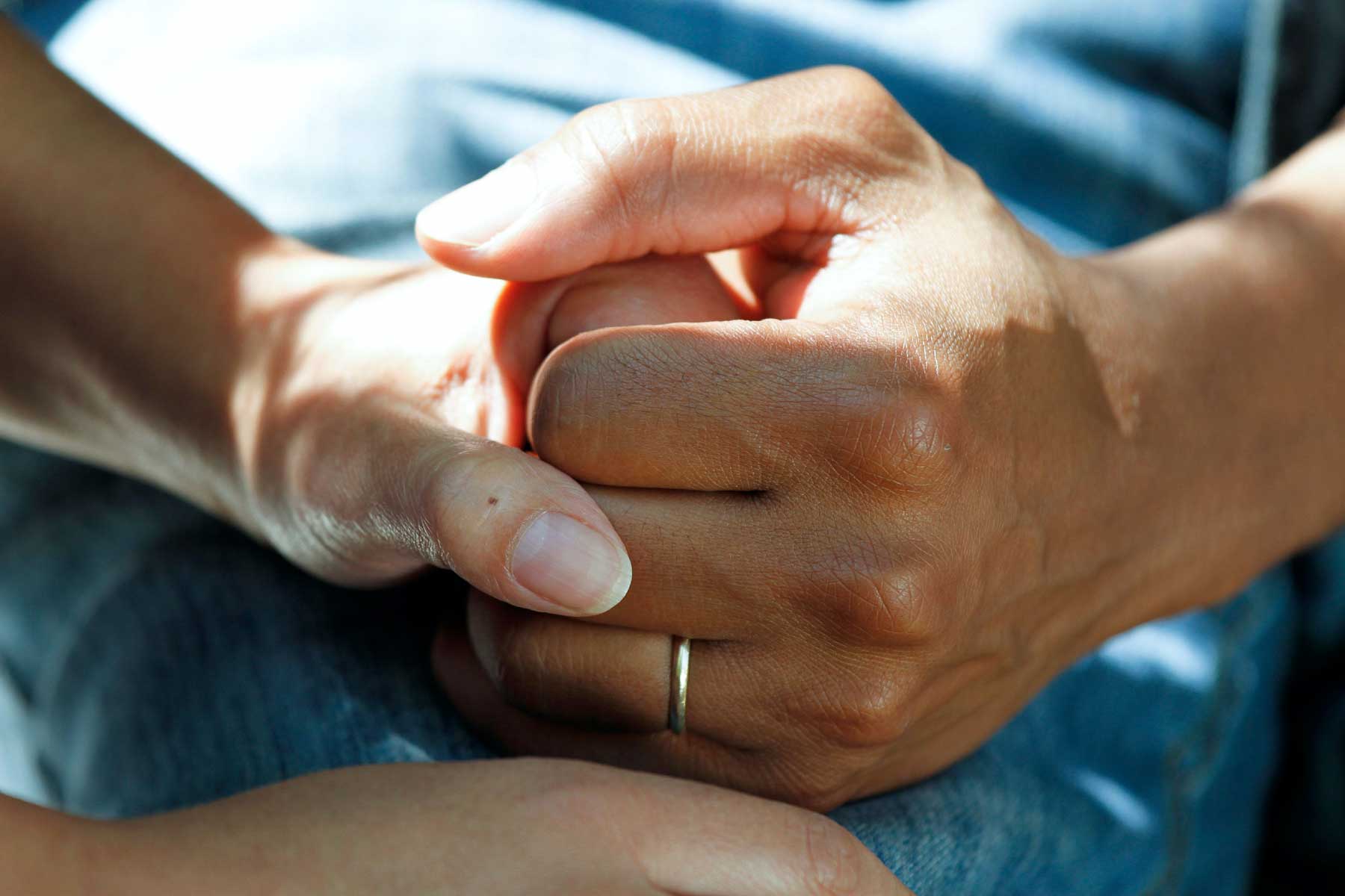 One person holding another's hand in support