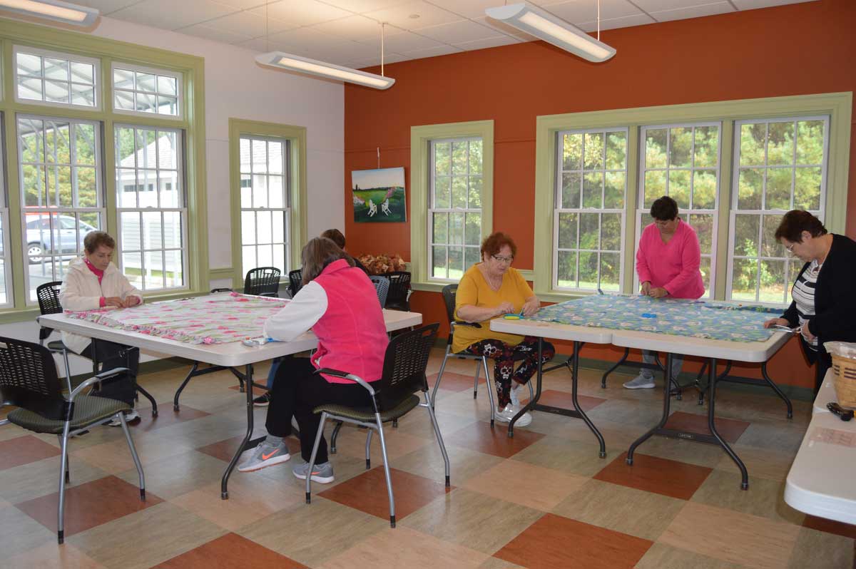 six women, including Janis Lefebre, working on comfort blankets