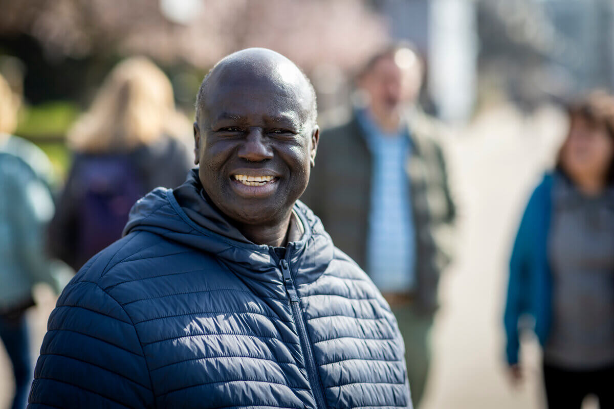 Black older smiling man in blue jacket