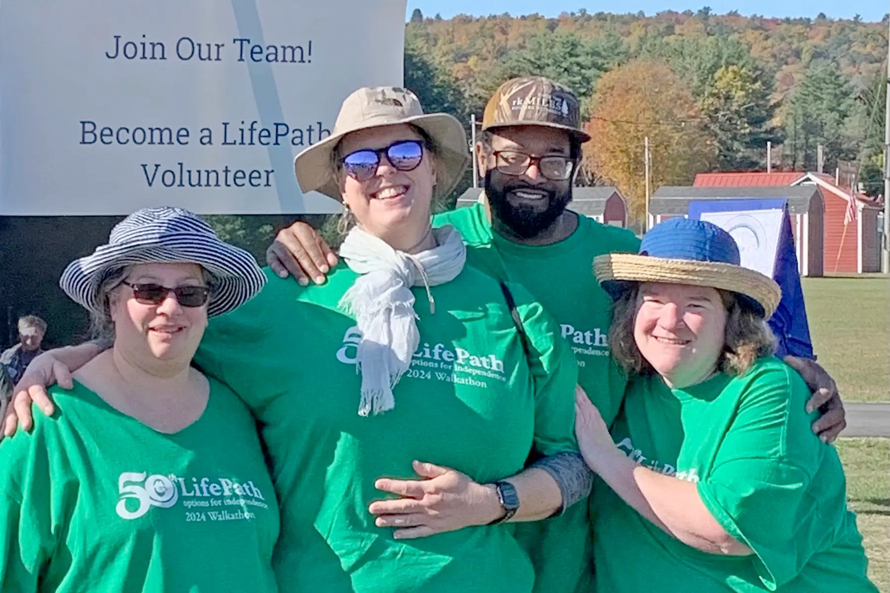 LifePath staff in matching t-shirts by a sign that says "Join Our Team! Become a LifePath Volunteer"