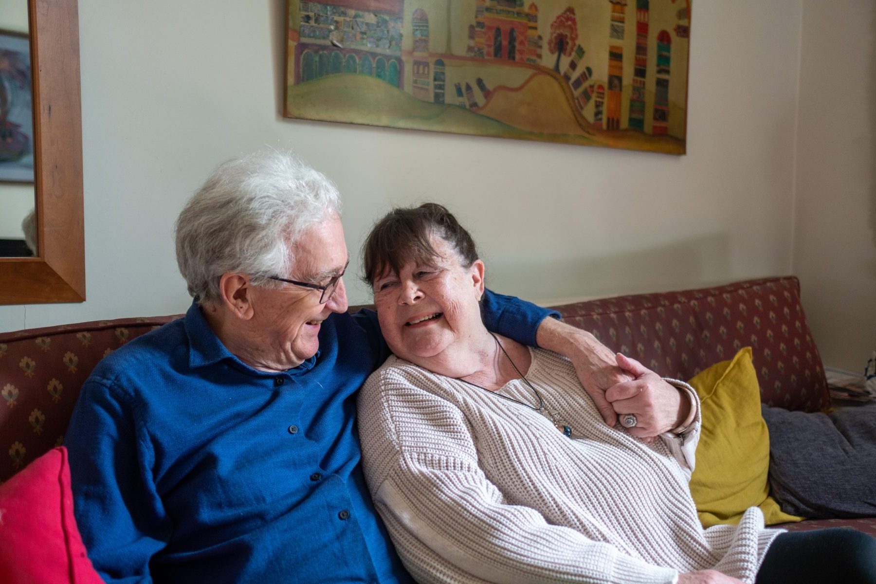 Older couple on a couch together smiling